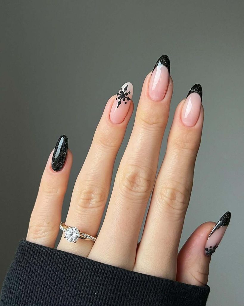 Black sparkling French tips with delicate snowflake design on nude pink base nail design