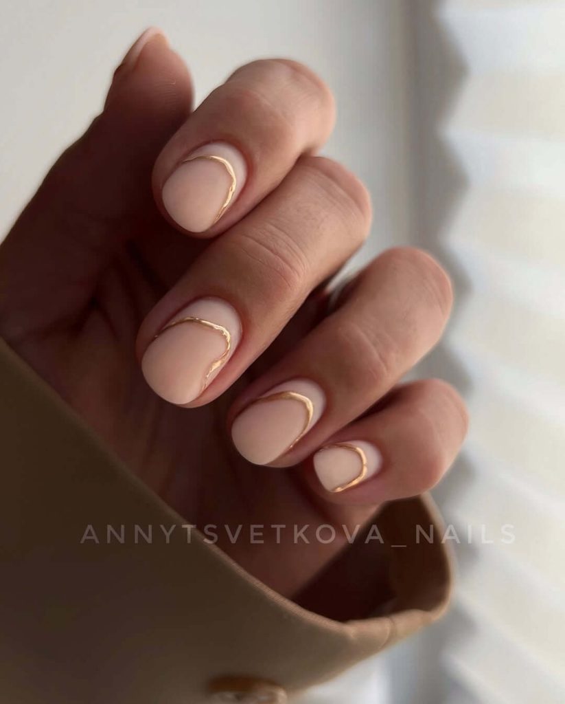 nude manicure with curved gold wire accents