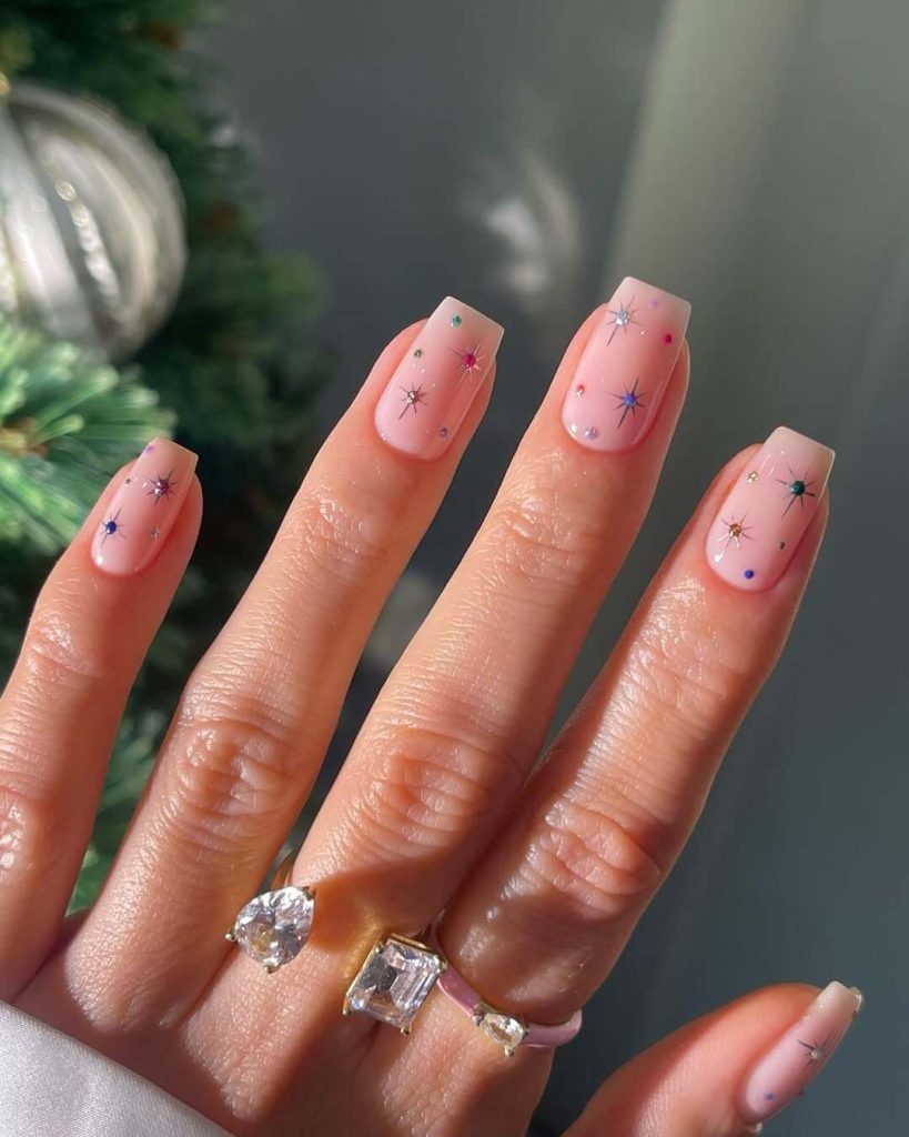 Colorful star designs on pink base new years nail art