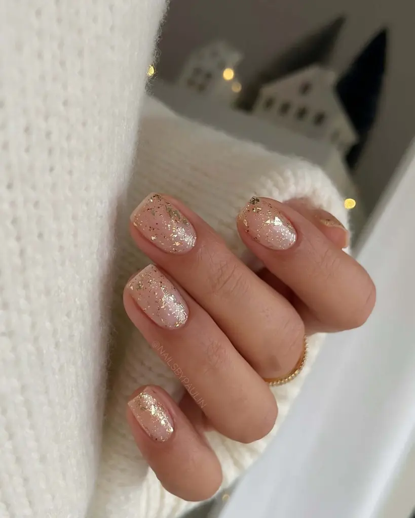 Gold foil flakes on sheer pink base new years nails