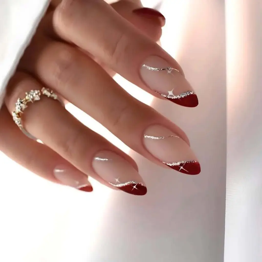 Red tips with sparkling silver line detail on nude base new years french nails design