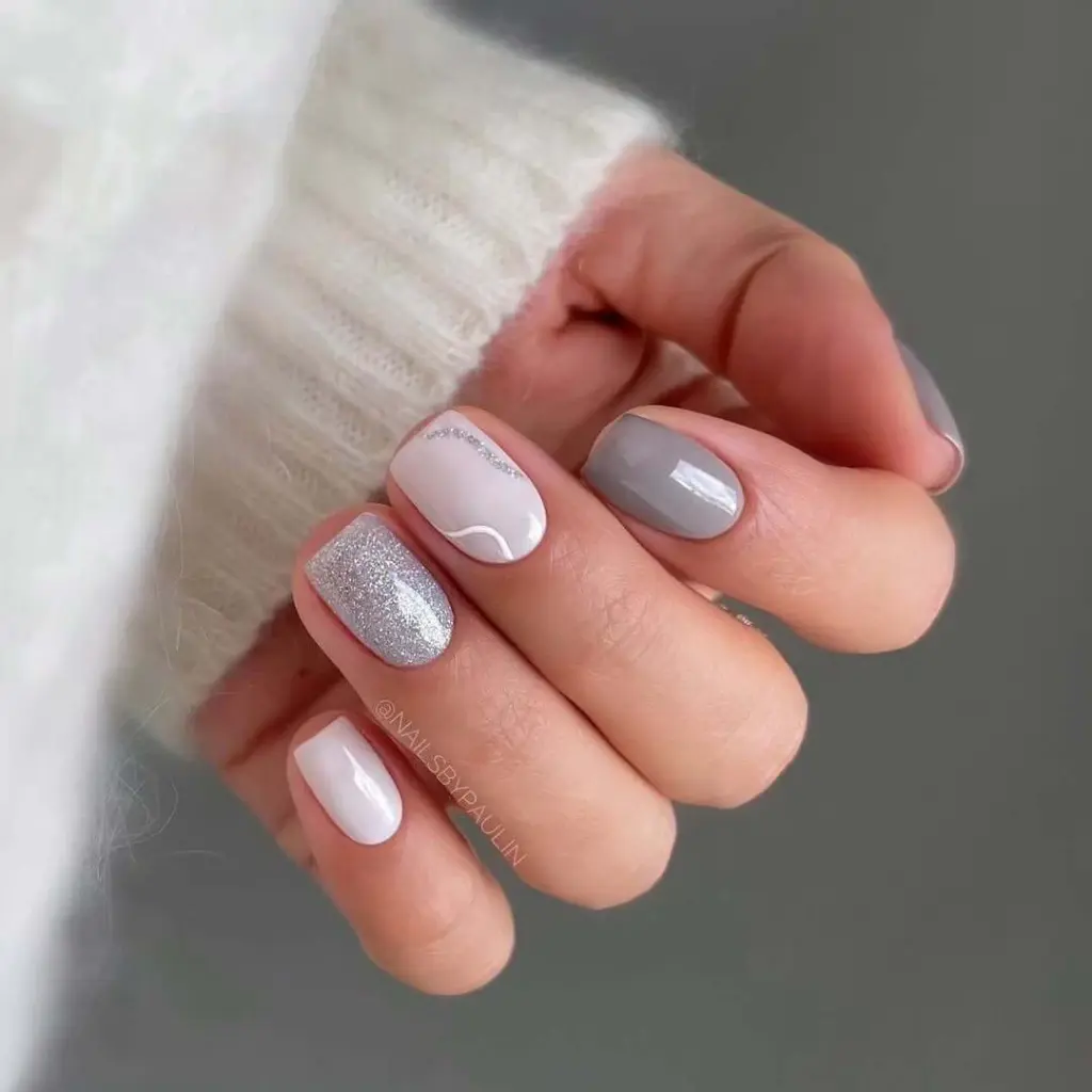 White and grey skittle nails with glitter accent and metallic stripe detail