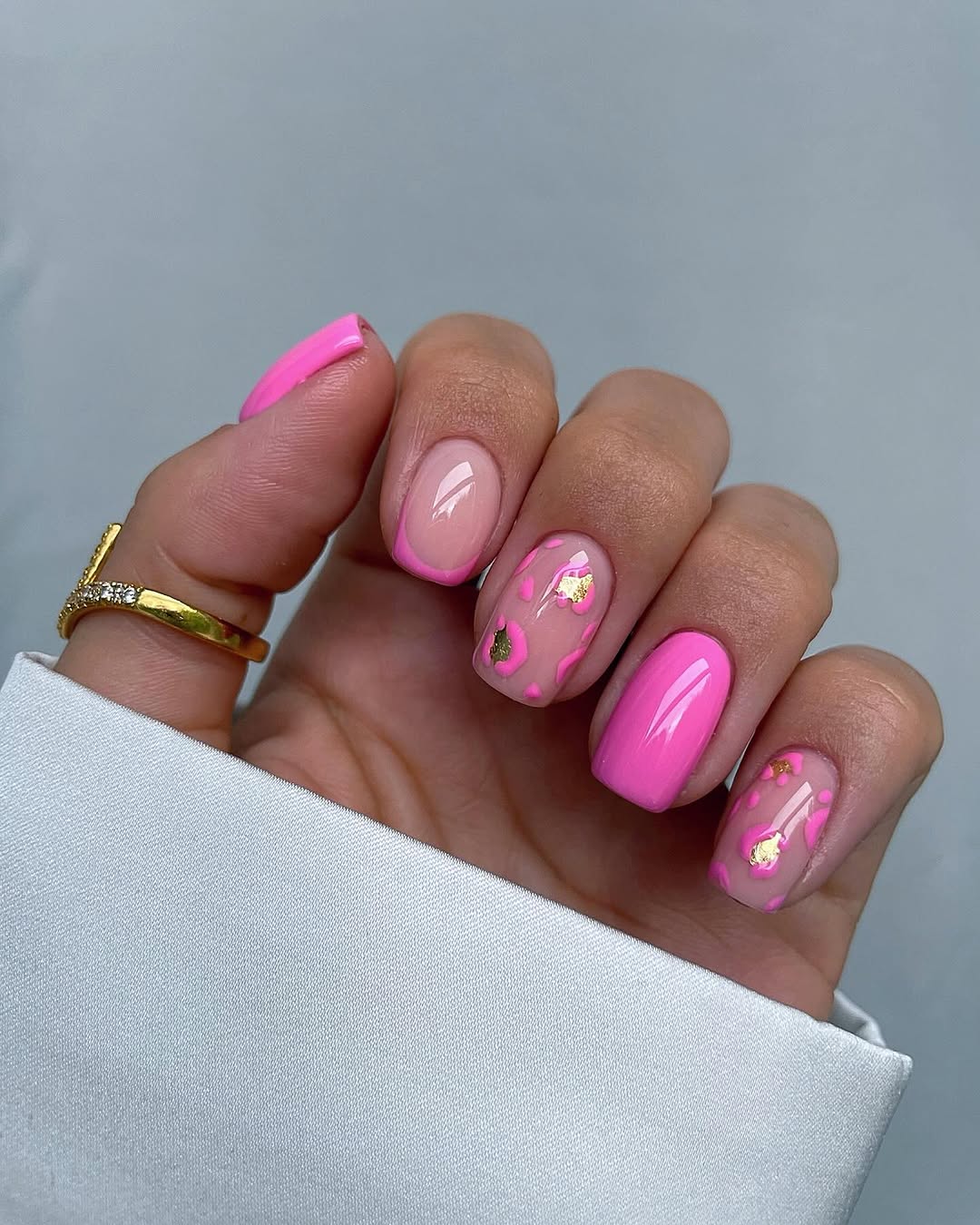 Short spring nails with pink mix design: light pink base, hot pink French tips and accent nail, gold foil flower details
