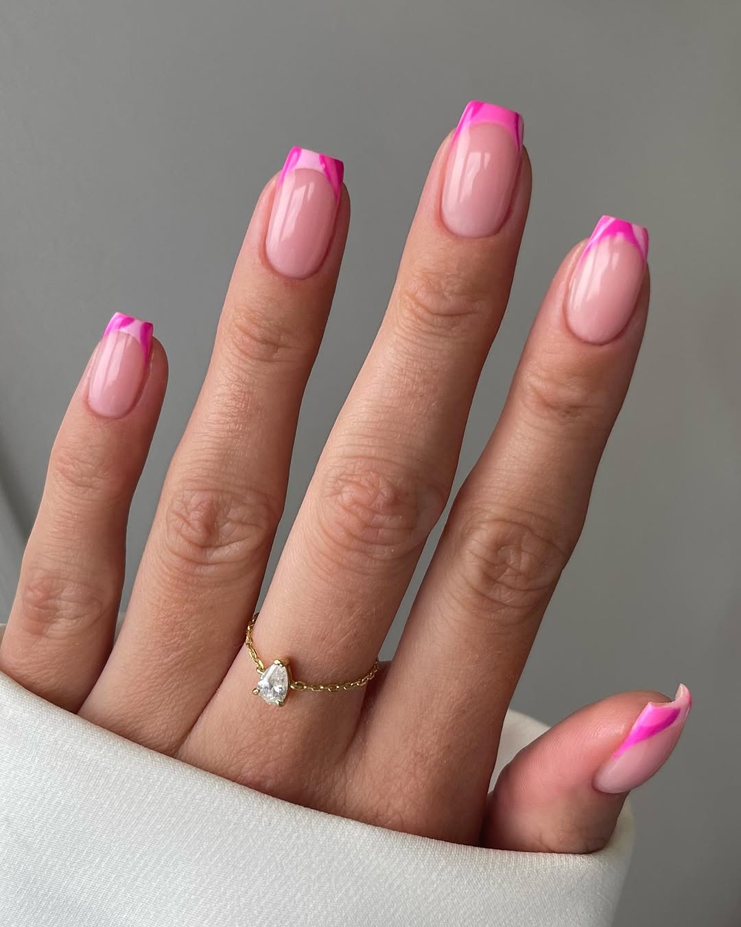 Long square nails with sheer pink base and two-toned pink French tips
