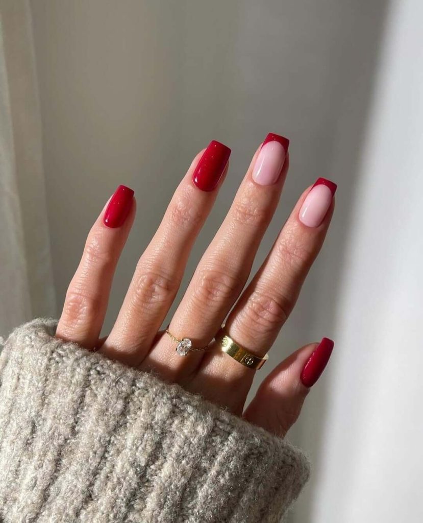 Alternating red and sheer pink with red French tip nails in squoval shape
