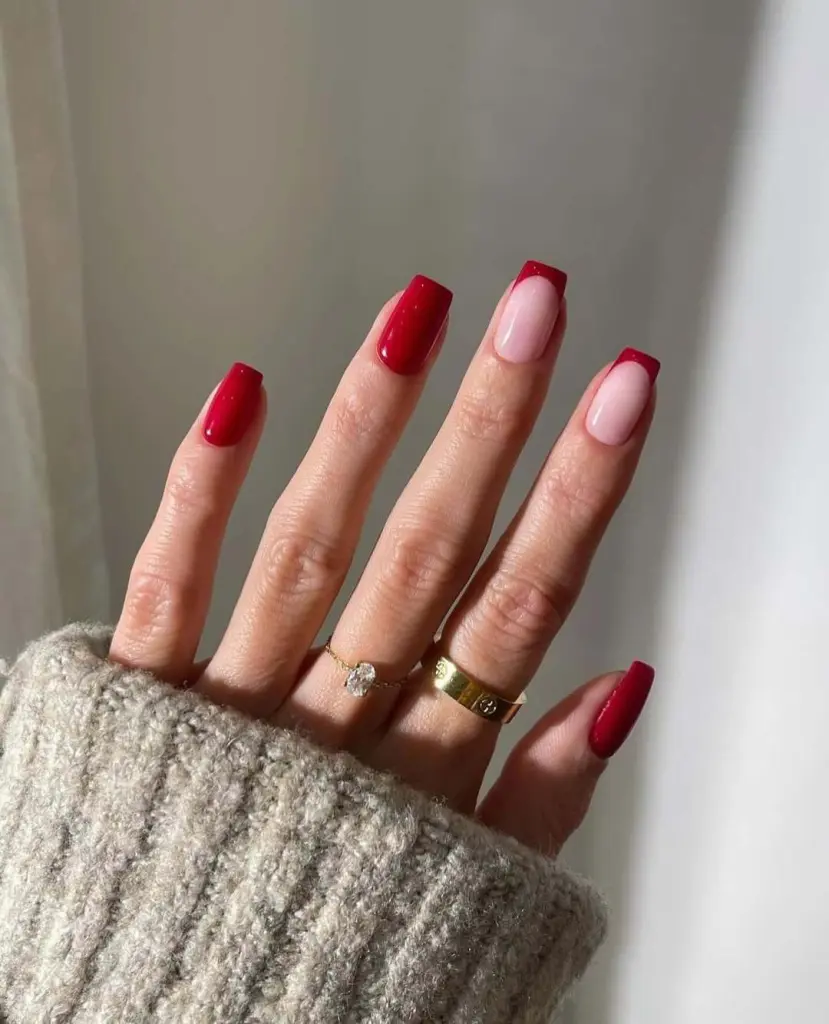 Alternating red and sheer pink with red French tip nails in squoval shape