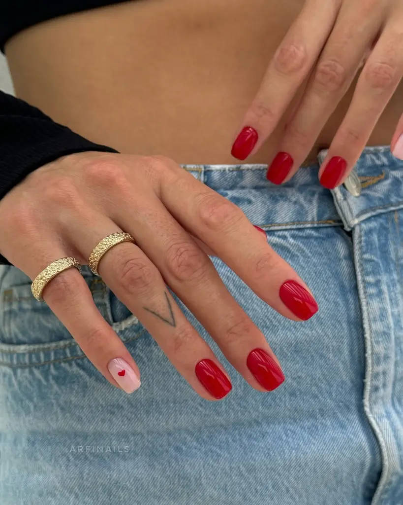 elegant short square nails alternating red polish and nude base with single heart accent