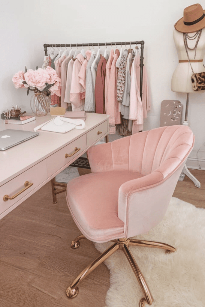 A feminine office with a plush pink velvet chair with gold legs
