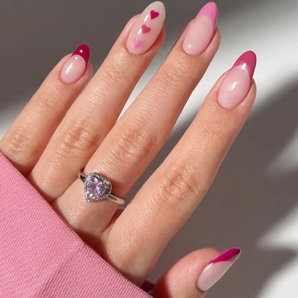 Pink gradient nails with tiny red hearts and magenta French tips