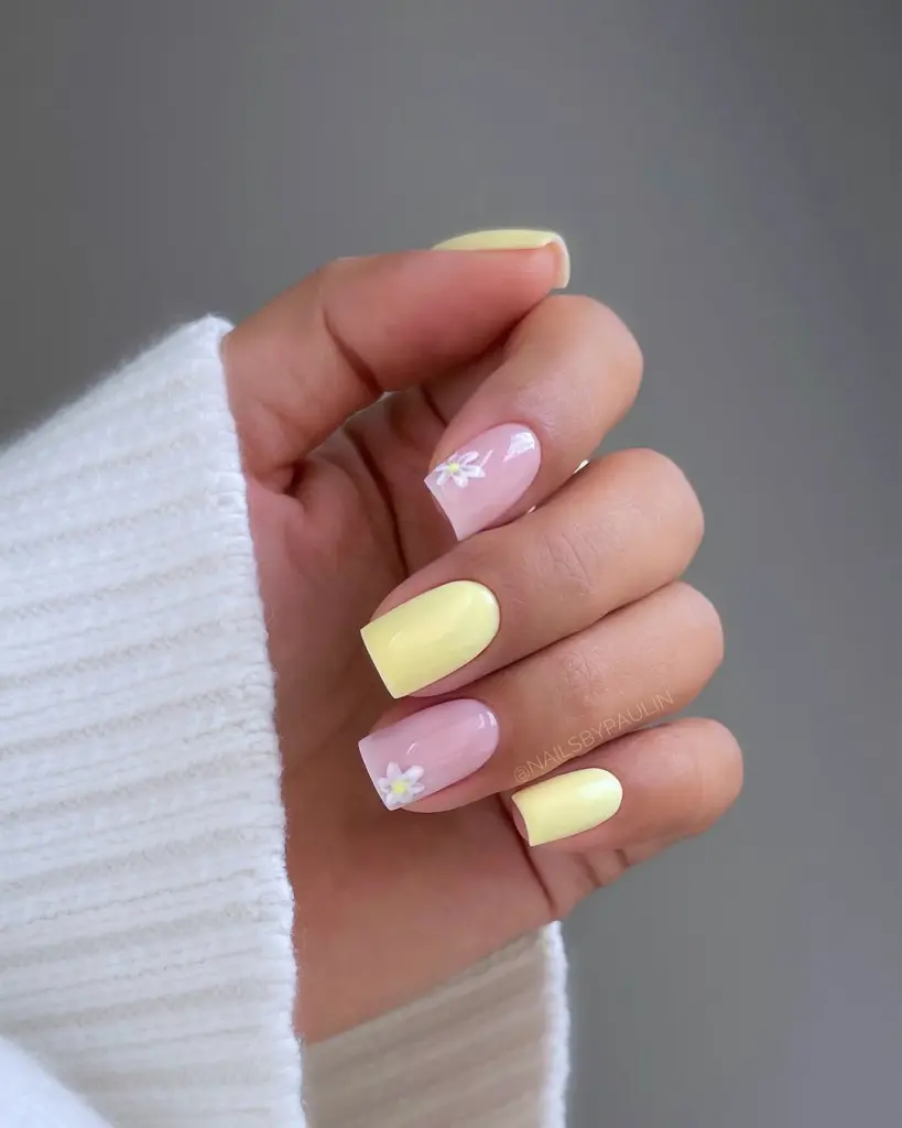 Alternating pink and yellow nails with white floral details
