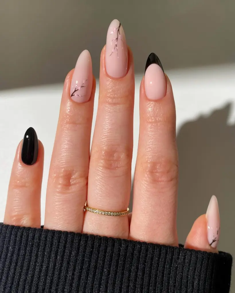 Almond spring nails with pink base, black French tips, black accent nail and cherry blossom branch design