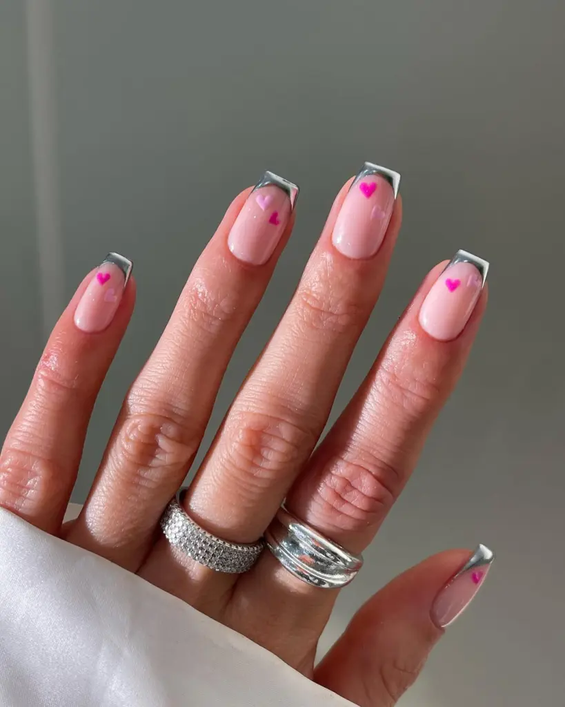 Pink nails with silver French tips and tiny heart accents
