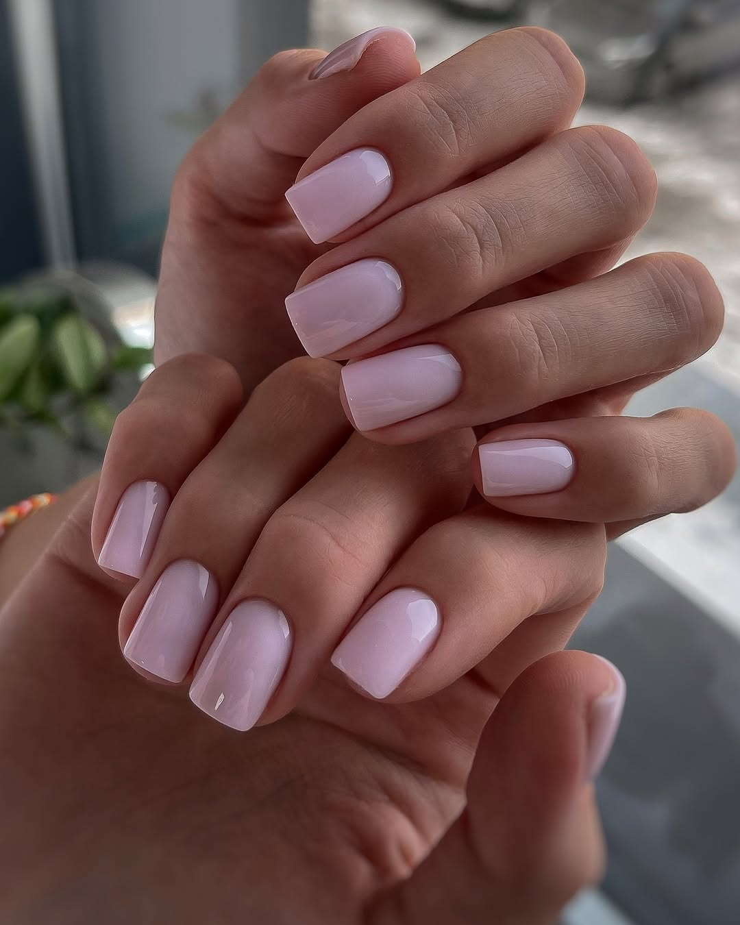 Short square nails with milky light pink polish
