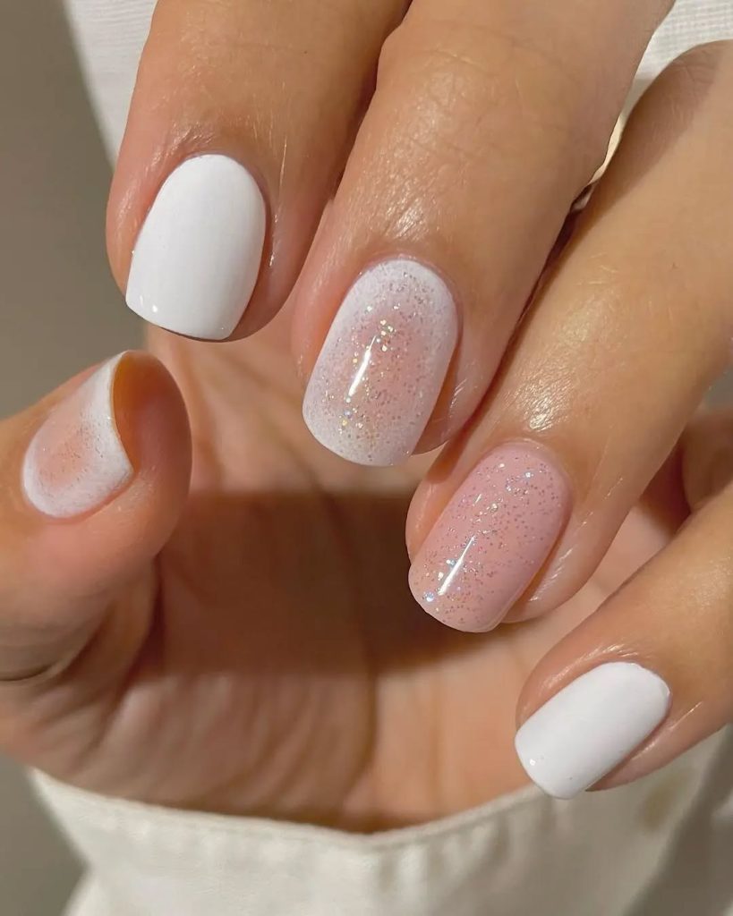 White and pink nails with iridescent glitter accents