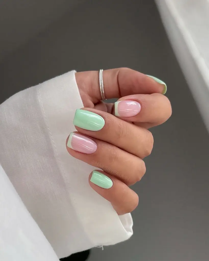Short square spring nails with alternating mint green and pink polish plus French tip accents