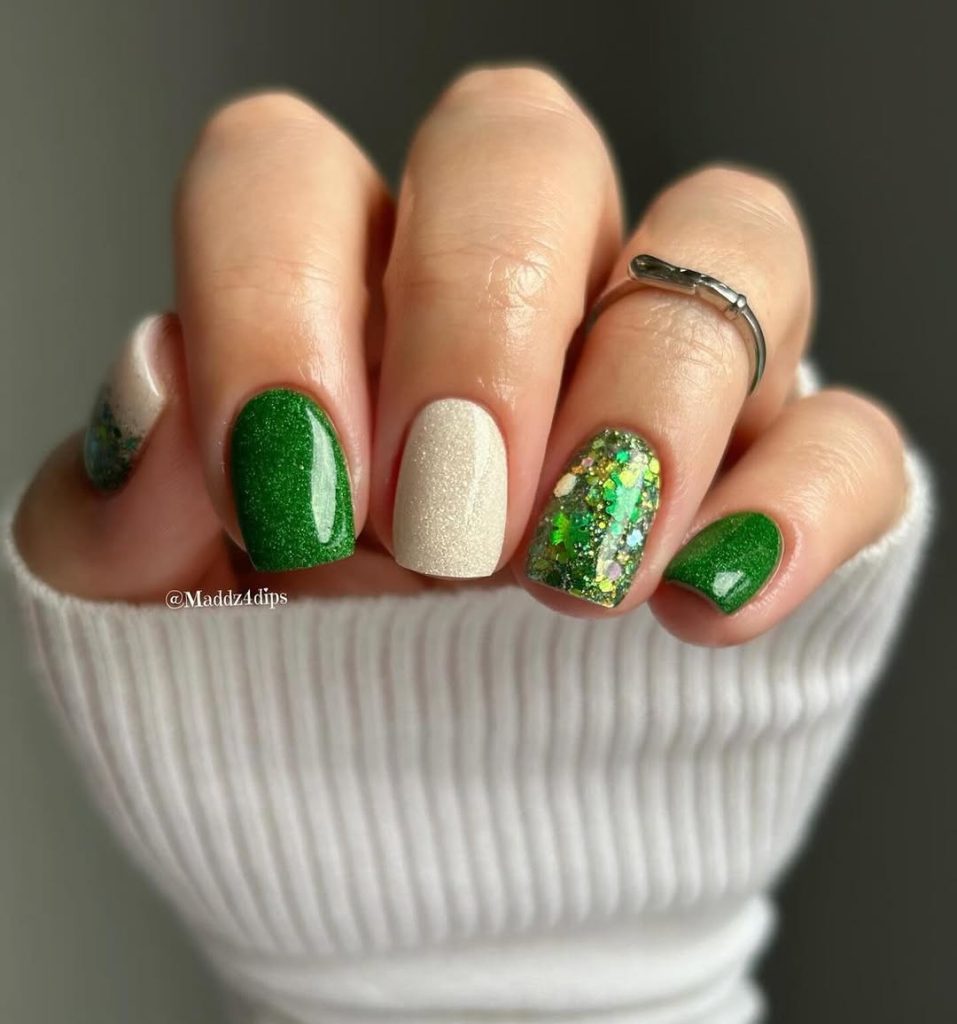Short nails with alternating emerald green and white polish, gold and green glitter accent nail
