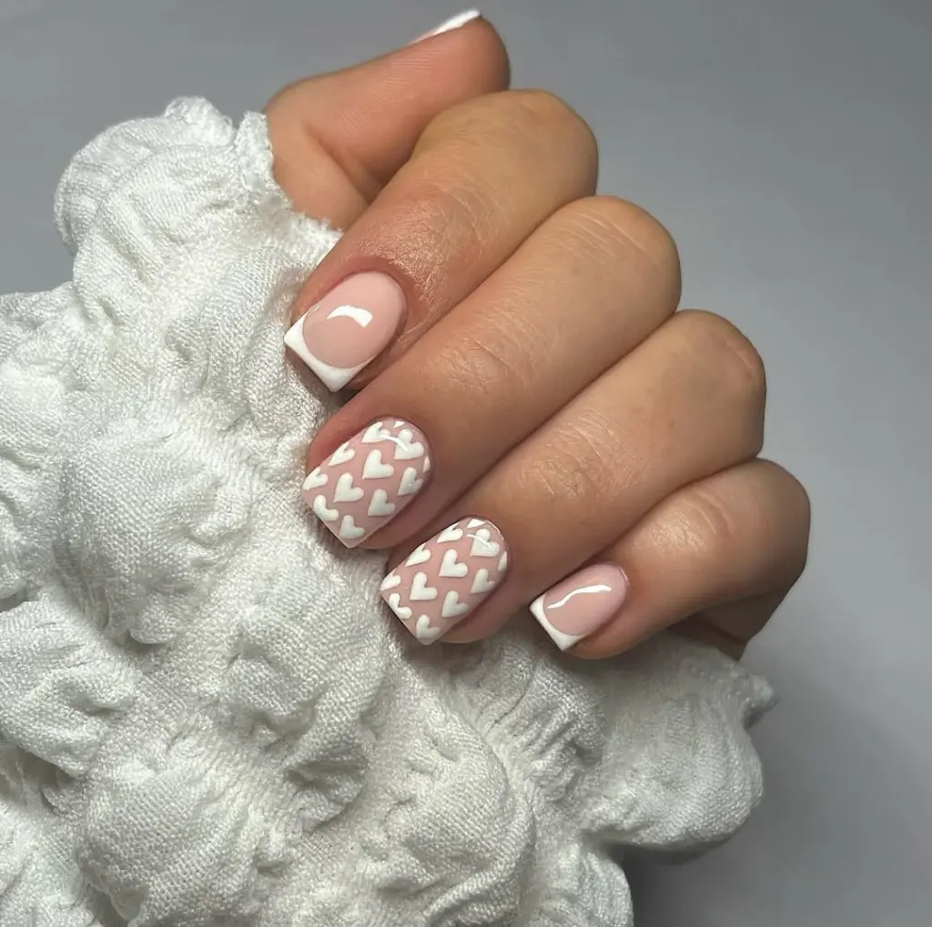 Short french tip nails with white heart pattern accent
