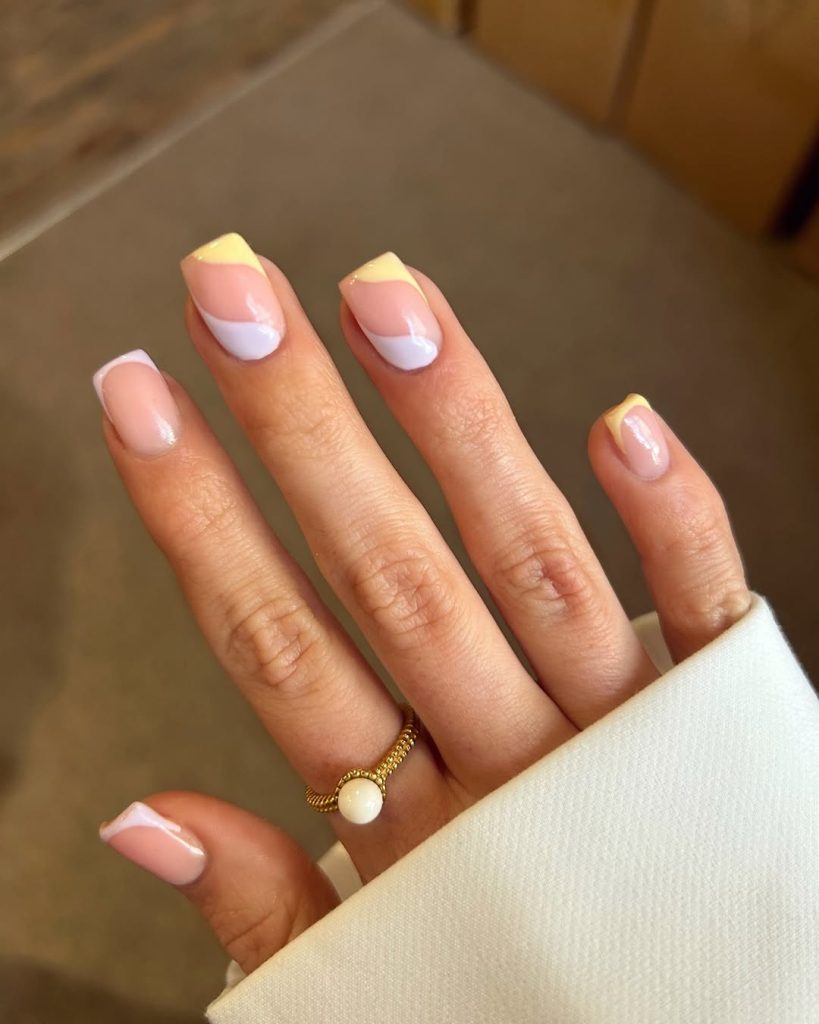 Classy square nails with nude pink base featuring alternating classic french tips and yellow angled french tips

