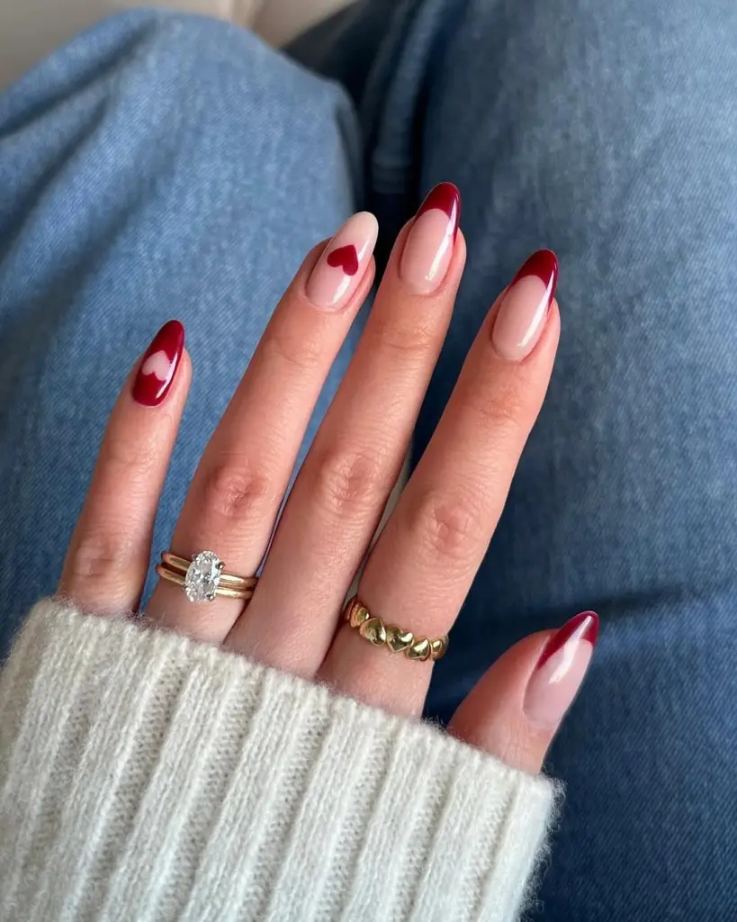 Sheer pink nails with red French tips and heart accents