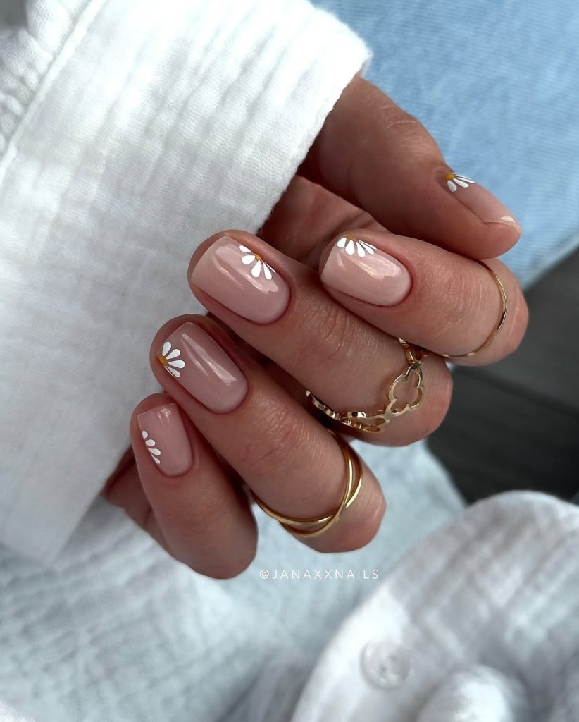 Short elegant spring nails with nude pink base and white corner daisy design