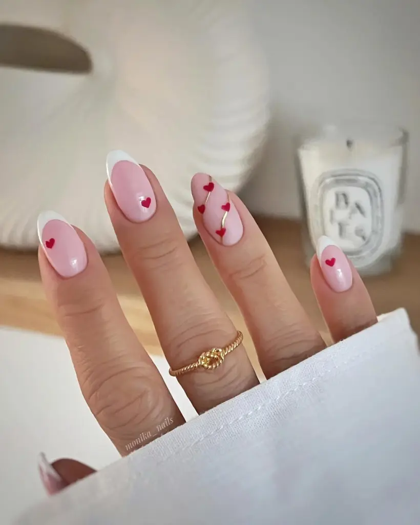 Valentine nails with French tips and tiny red hearts
