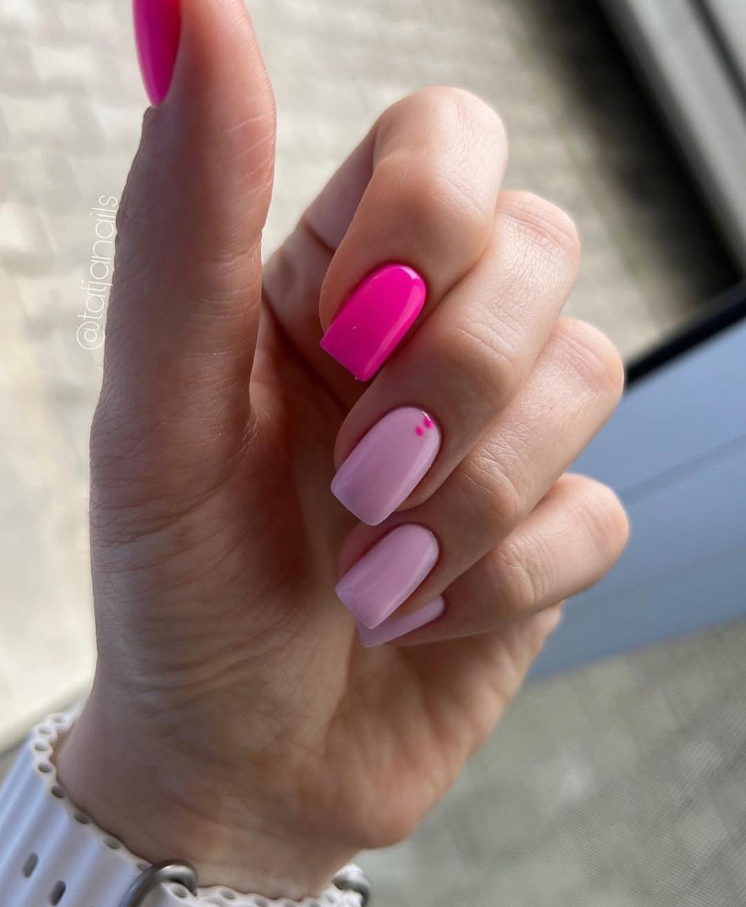 Short square pink nails with mixed design: baby pink base with dots and hot pink accent nail
