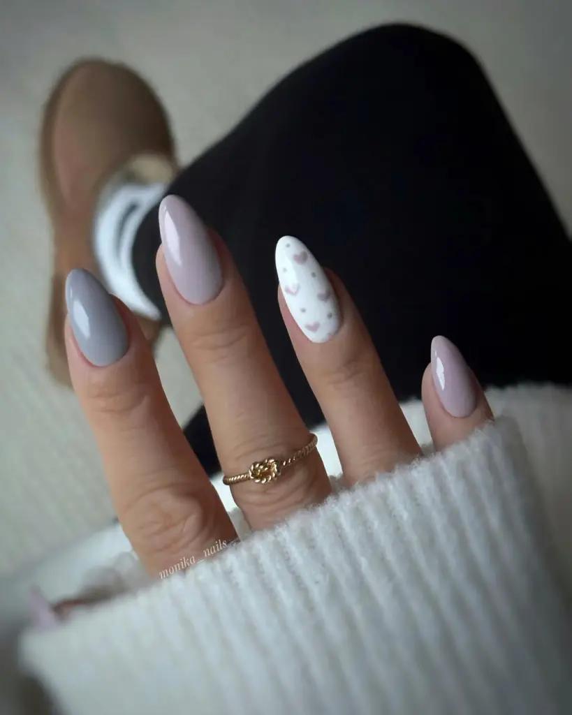 Neutral almond valentine day
nails with white heart accent nail and gold ring