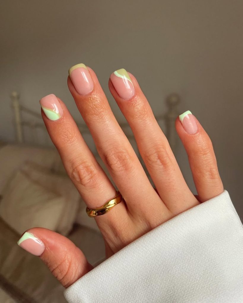 Classy spring nails with sheer pink base and sage-mint green abstract french tips