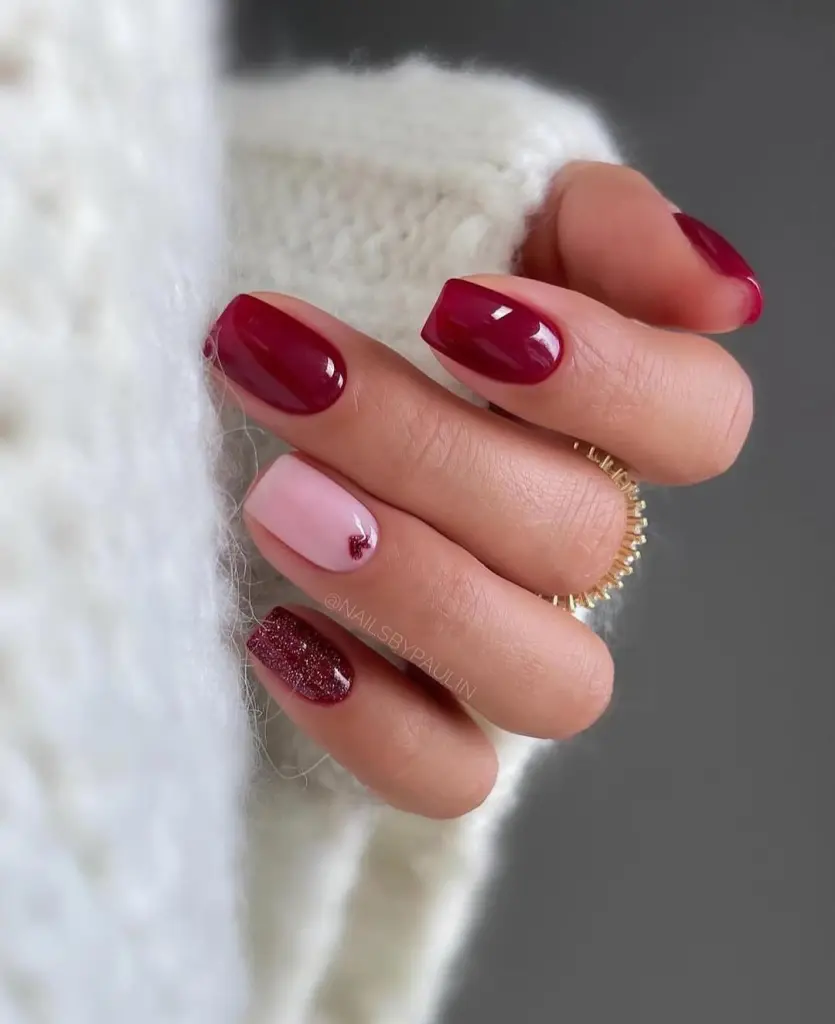 Short burgundy and pink valentine day nails with heart accent and glitter detail
