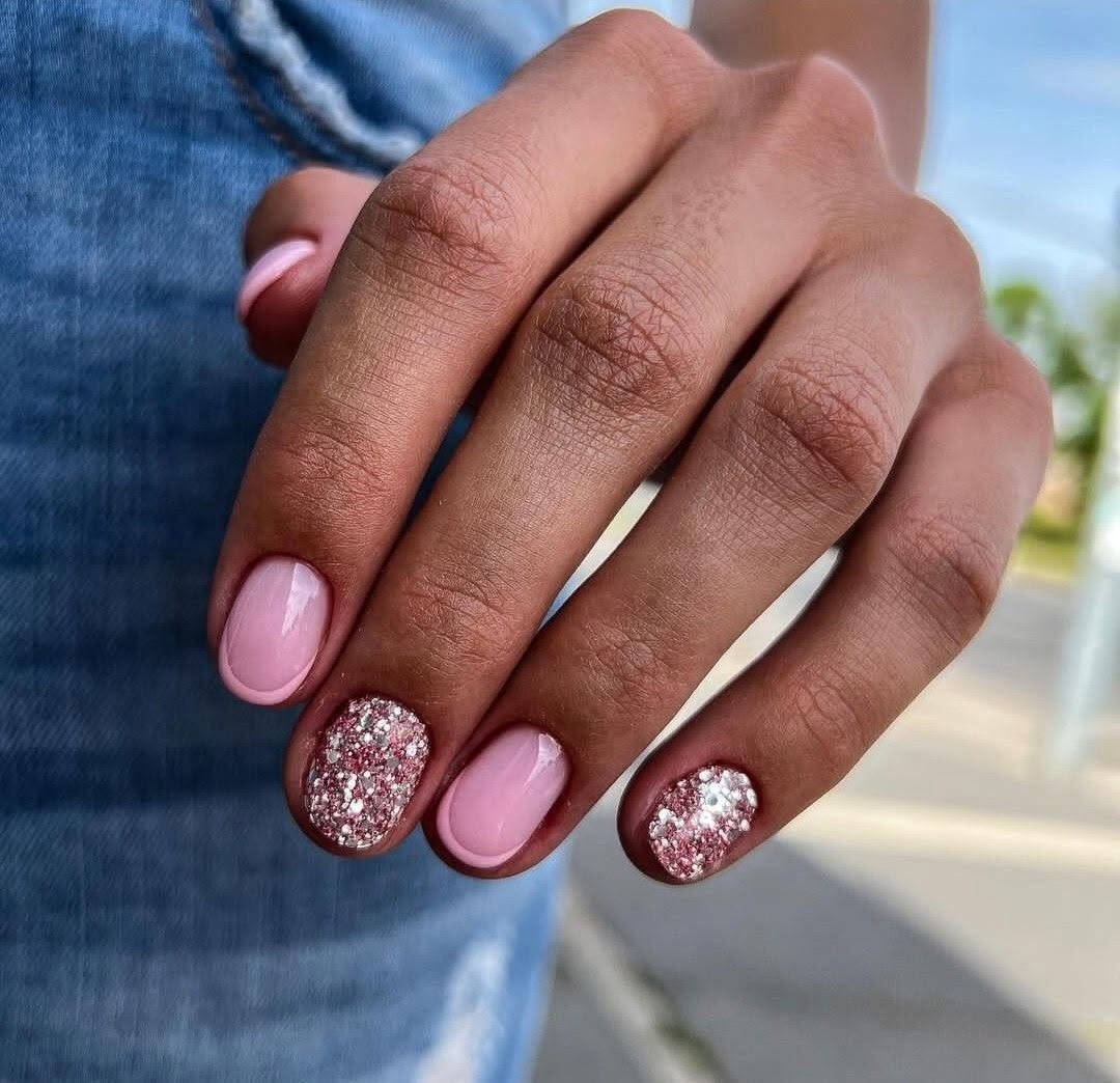 Short round nails with pink French tips and chrome pink glitter accent nails