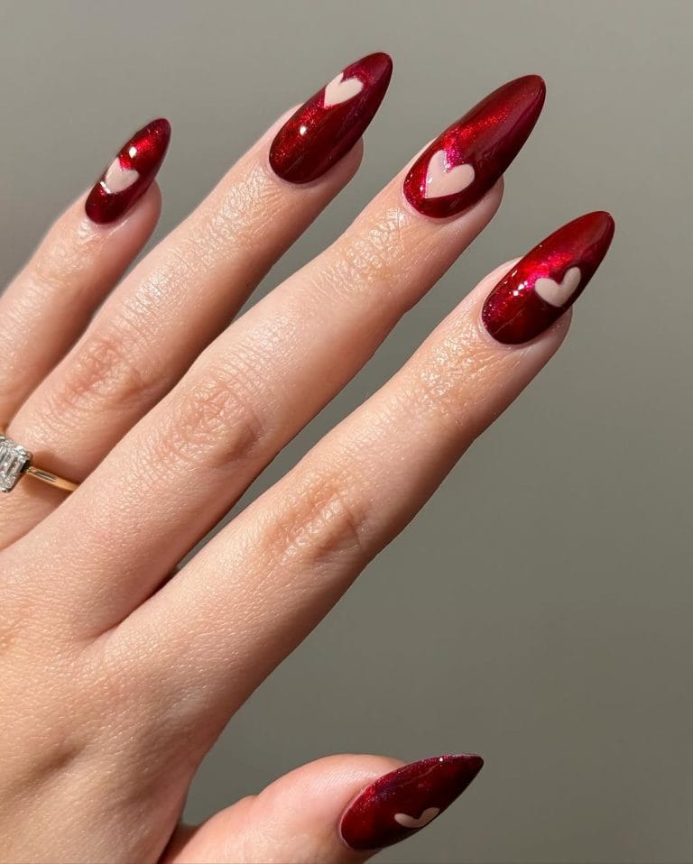 Deep red metallic Valentine day nails with negative space heart designs