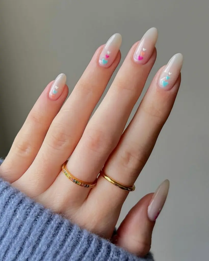 Sheer nude nails with pastel pink and blue micro hearts