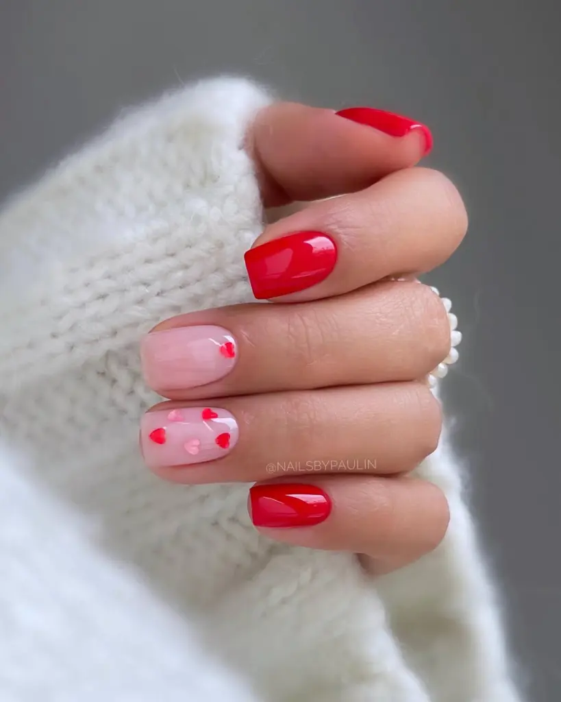 Red and pink Valentine's nails with scattered heart pattern