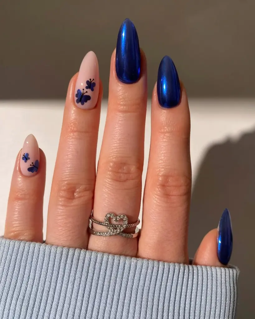Almond nails with cobalt blue chrome and nude base butterfly nail art spring design