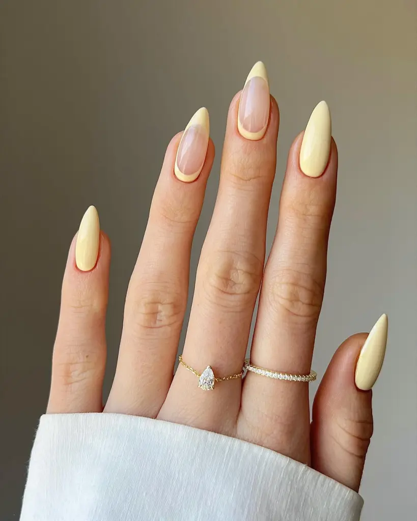 Classy spring almond nails alternating between pastel yellow and sheer pink base with yellow outline frames
