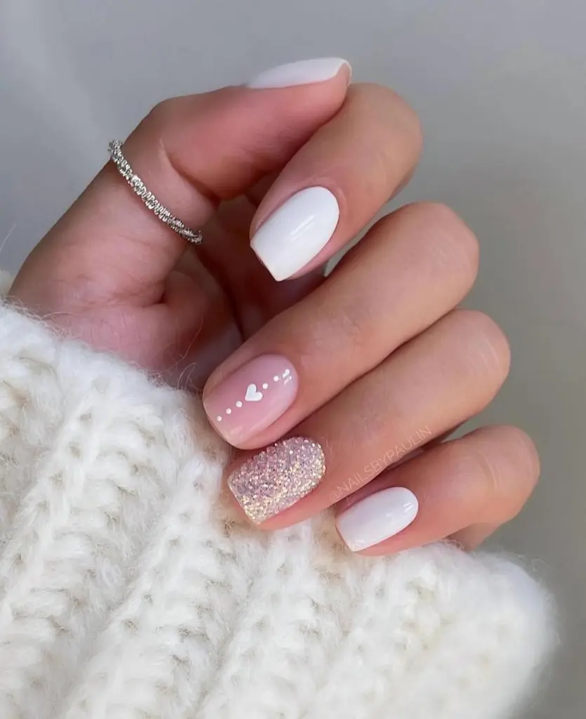 White and pink nails with heart details and iridescent glitter accent nail
