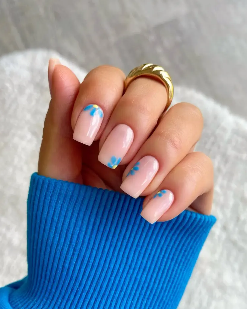 Elegant square nails with sheer pink base and sky blue flower details
