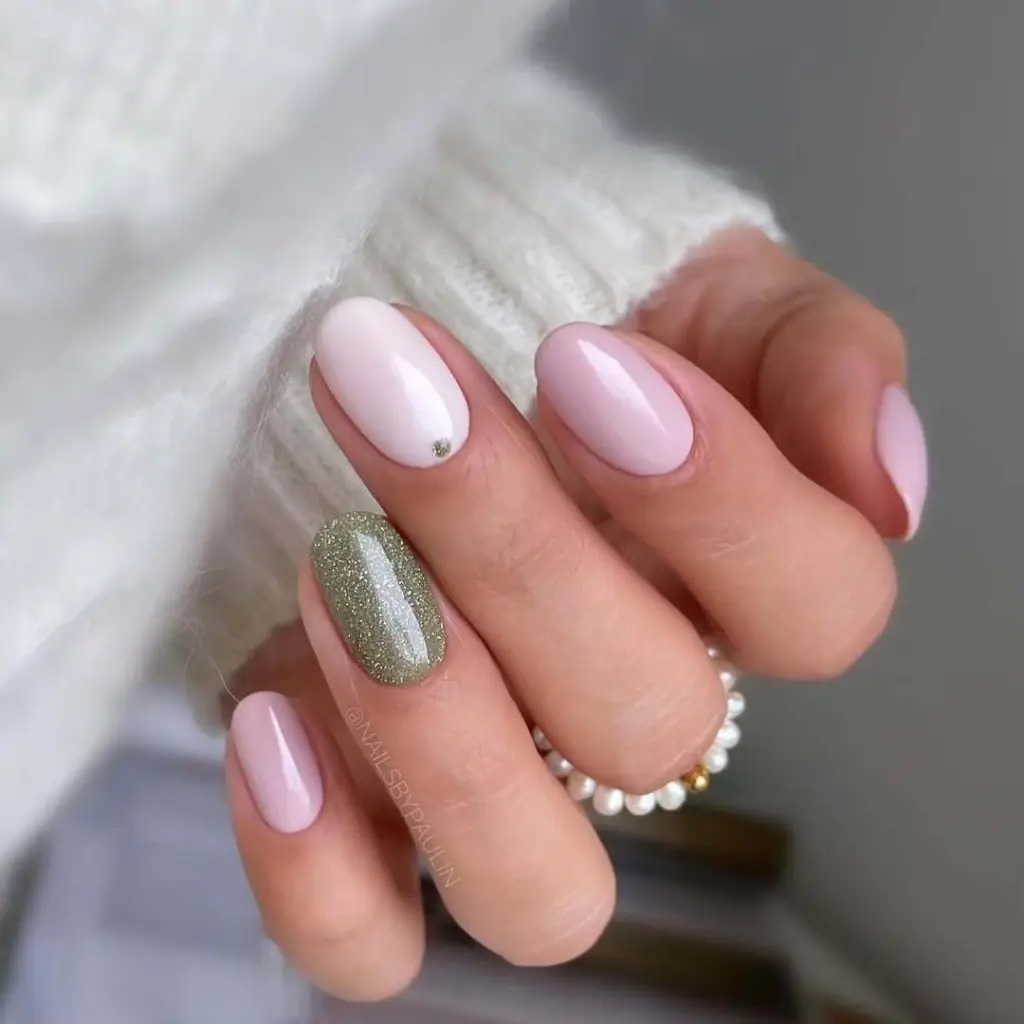 Pink almond nails with sage glitter accent and crystal detail