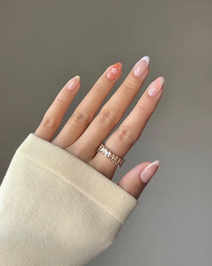 Sheer pink spring almond nails with curved line accents,  floral details and orange accent nail

