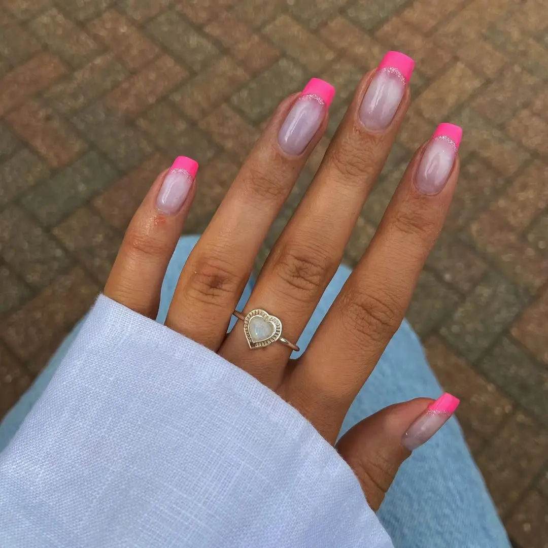 Long almond nails with milky pink base and hot pink French tips