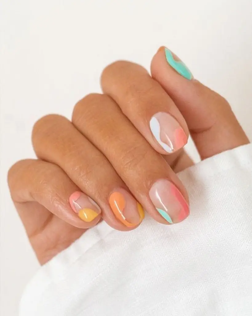 Pink nails with abstract swirls in white, coral, yellow and mint green
