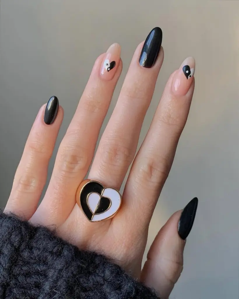Nude nails with black accents and mini black hearts