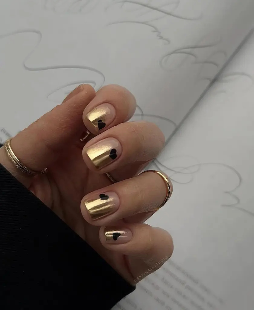 Short gold chrome valentine day nails with black heart designs
