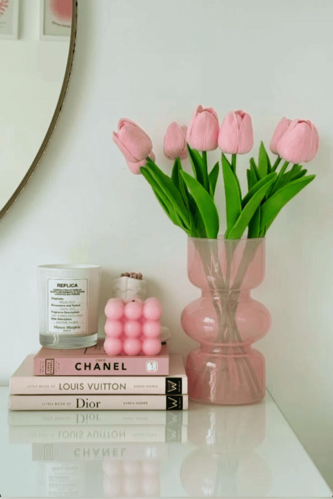 fashion books, pink flowers, and candles as decor