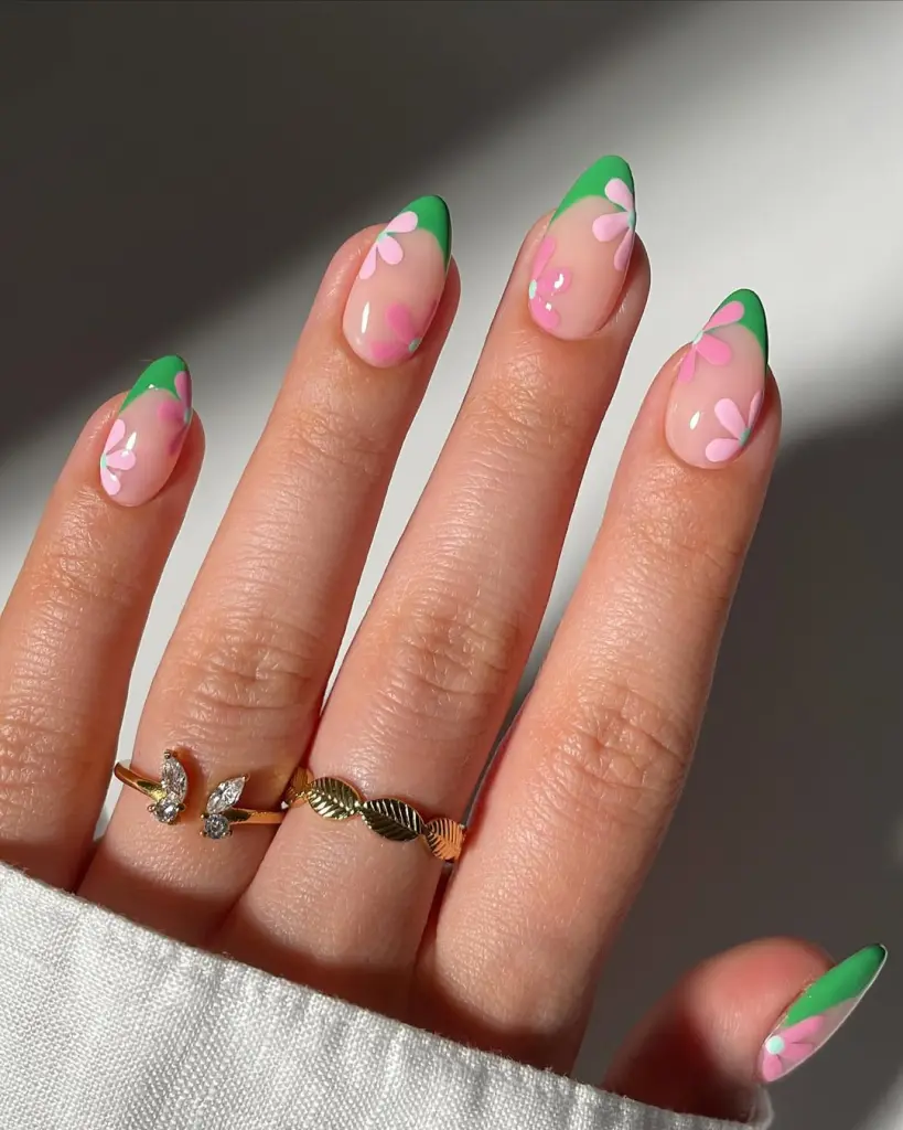 Sheer pink spring nails with green French tips and pink abstract flowers
