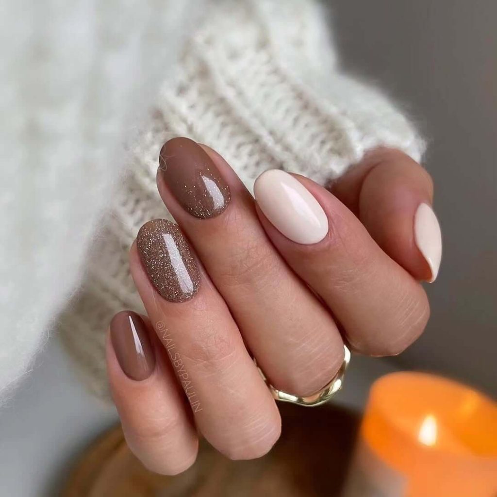 Taupe and white oval nails with bronze glitter accent