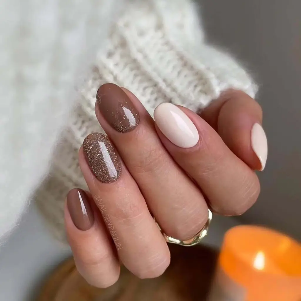 Taupe and white oval nails with bronze glitter accent