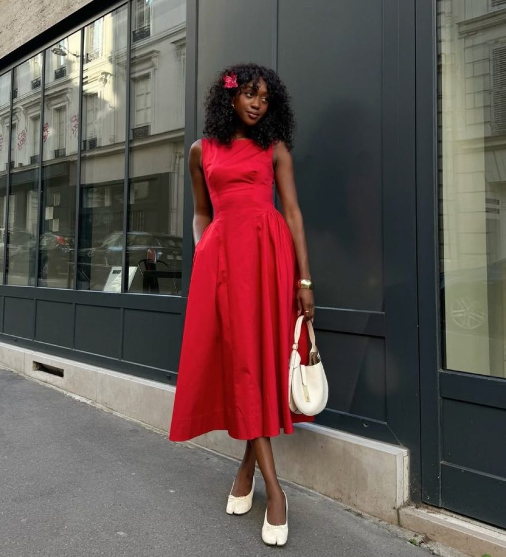 Woman in red sleeveless midi dress with cream ballet flats and white handbag