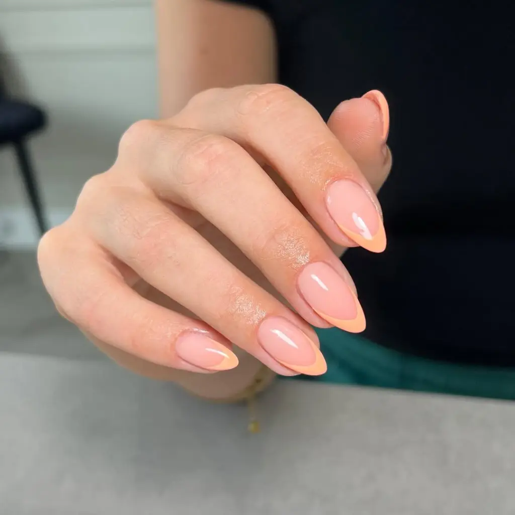 Almond shaped transparent pink nails with delicate peach French tips creating a subtle spring old money aesthetic