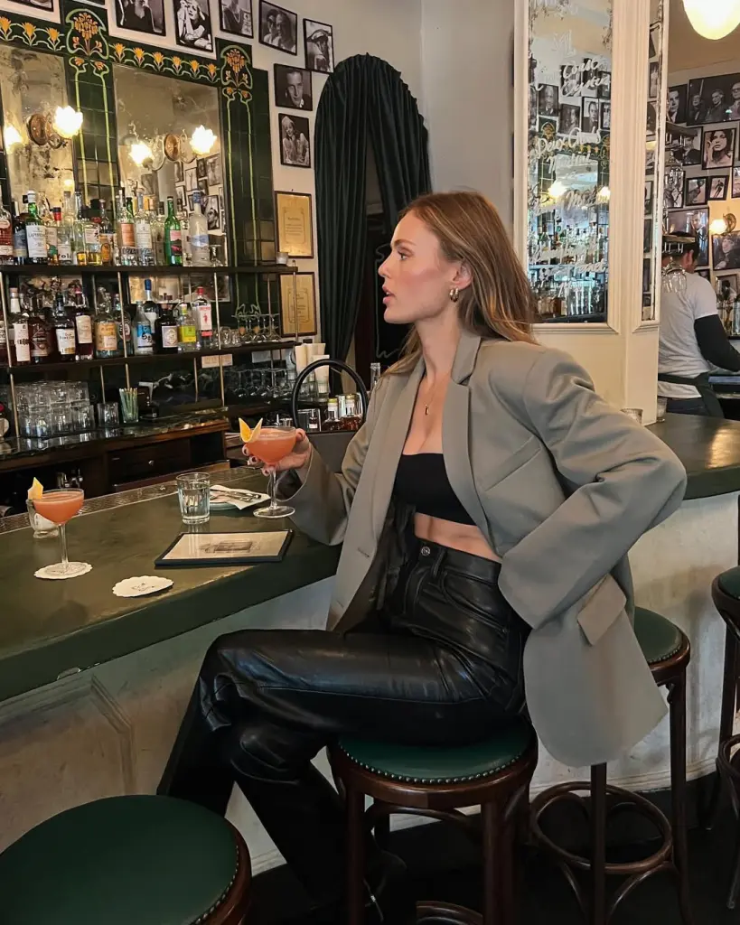 Woman in grey blazer, black crop top and leather pants
